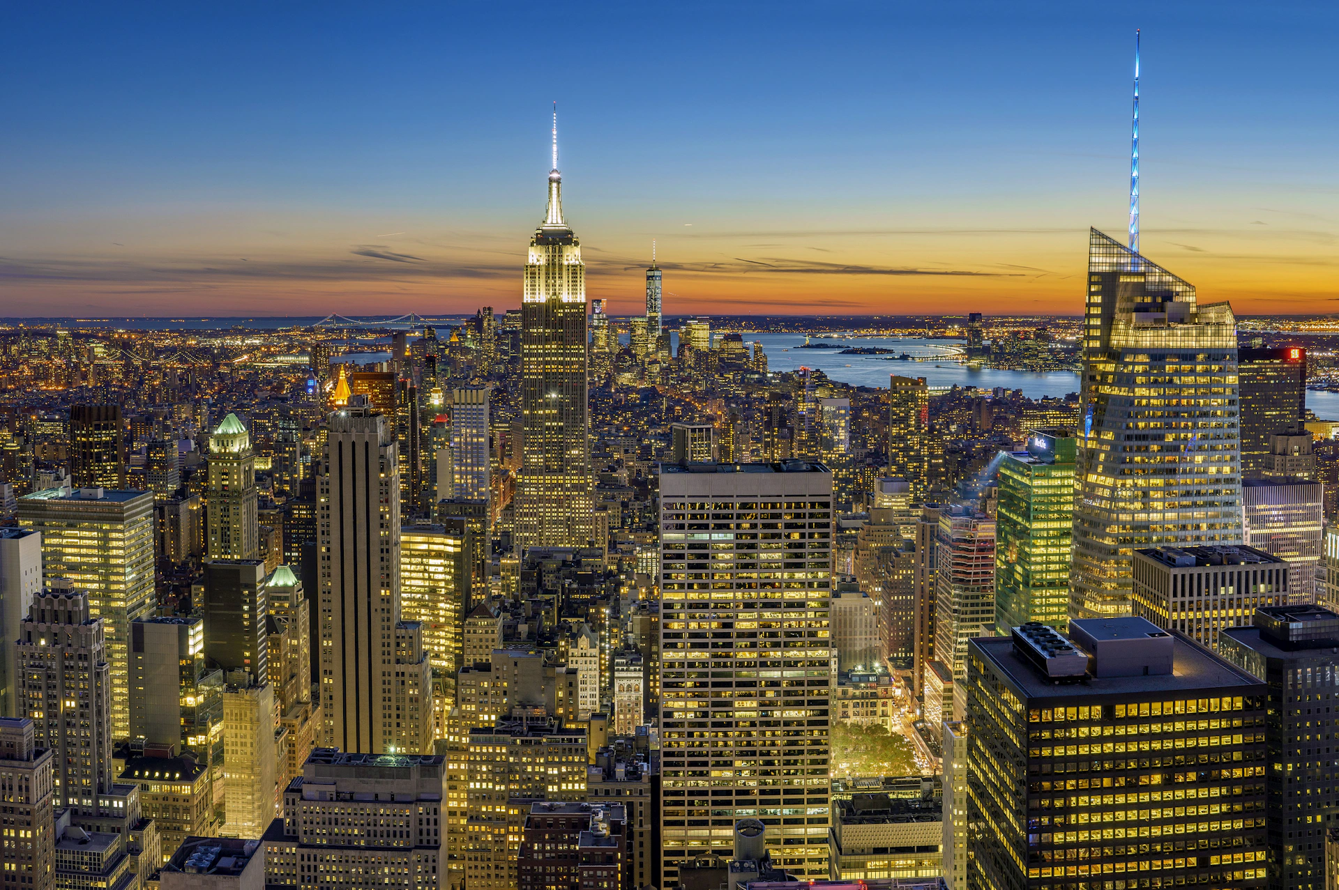 An illuminated city skyline at blue hour